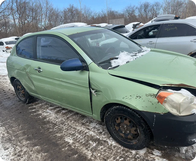 Damaged green car in snow